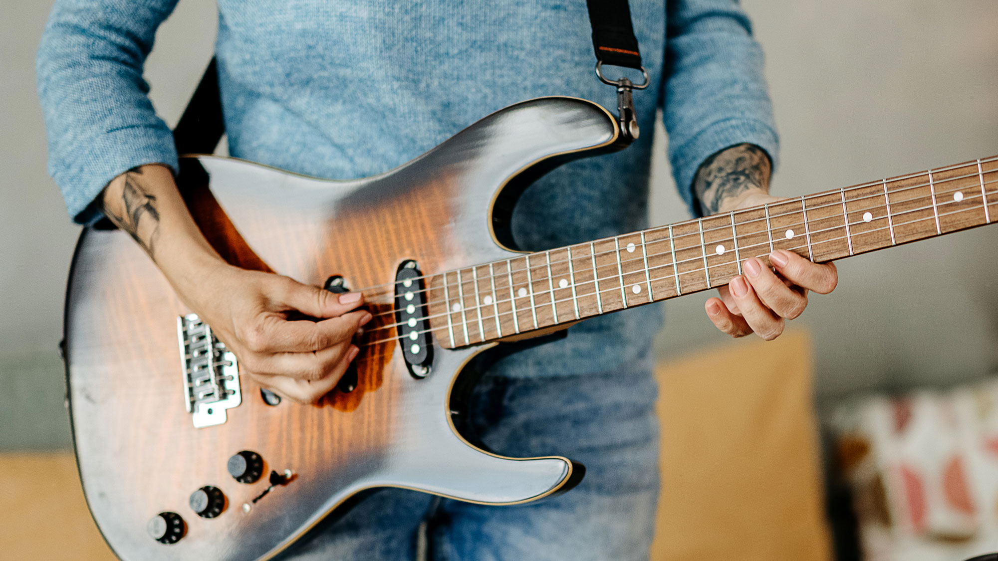 Woman playing an electric guitar at home
